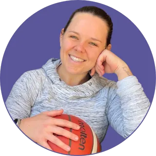 Rach smiling with a basketball tucked under her arm